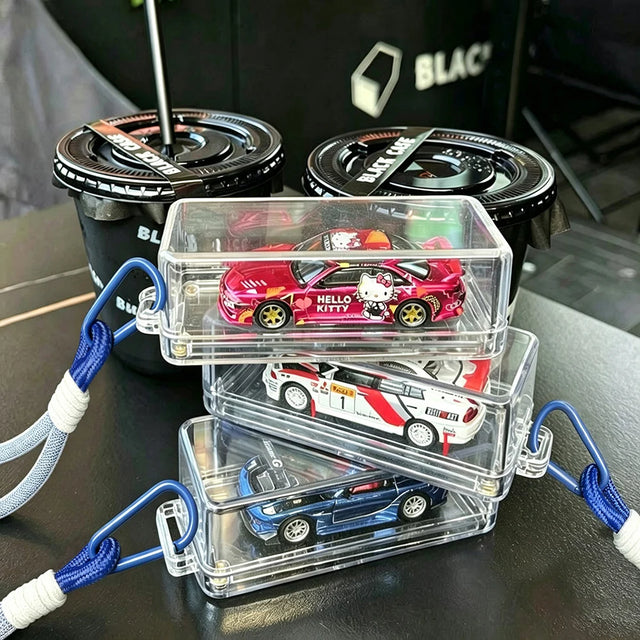 Three KicarBox cases stacked on a table, each holding a 1:64 diecast car, blue lanyards attached