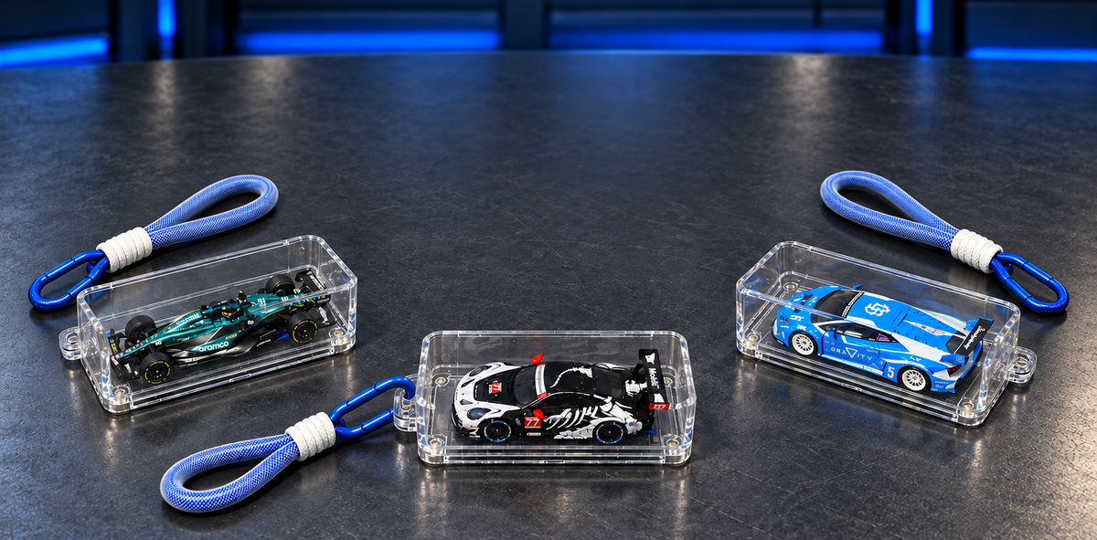 Three KicarBox display cases holding 1:64 diecast cars, blue lanyards and carabiner clips attached, on a dark surface